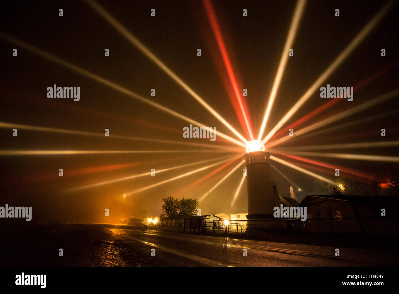 Les faisceaux lumineux d'émission phare en mer la nuit Banque D'Images