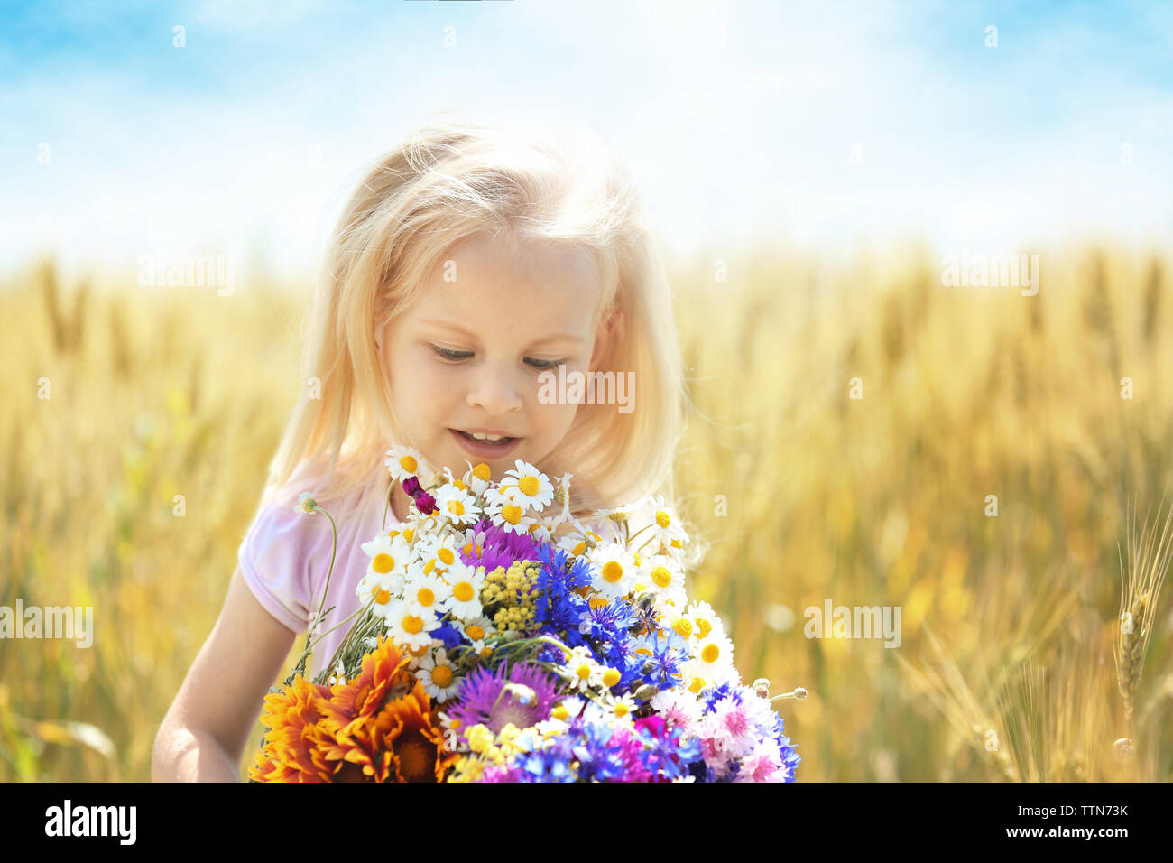 Petite fille avec bouquet de fleurs dans le domaine Banque D'Images