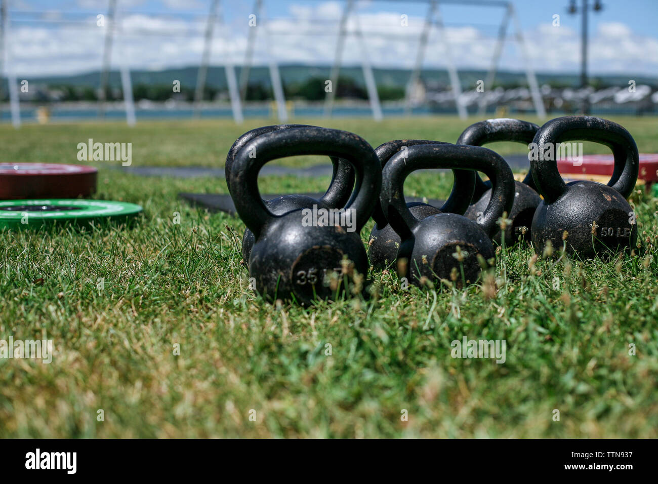 Close-up of kettlebells on grassy field au parc en journée ensoleillée Banque D'Images