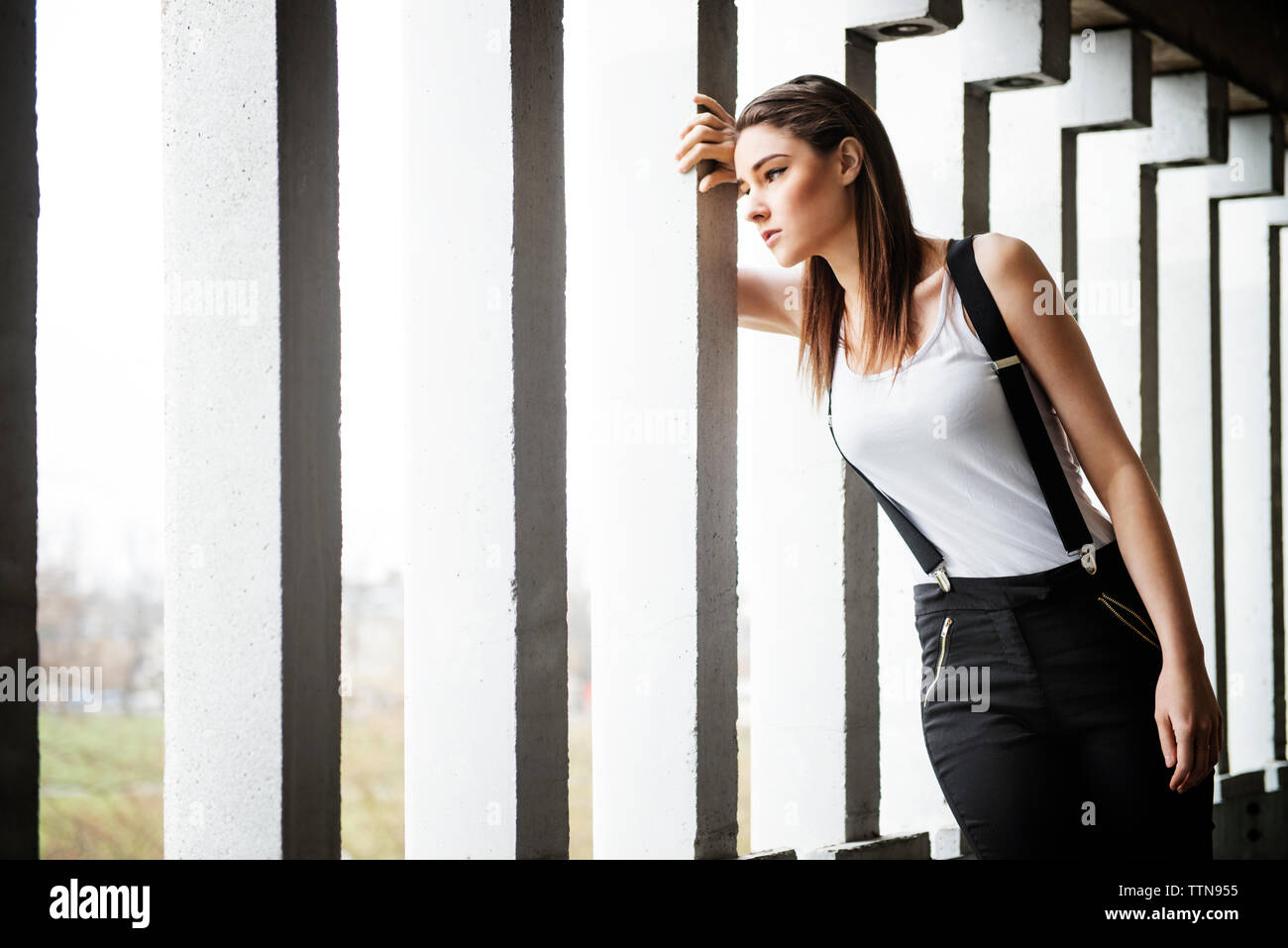 Déprimé woman leaning on column Banque D'Images