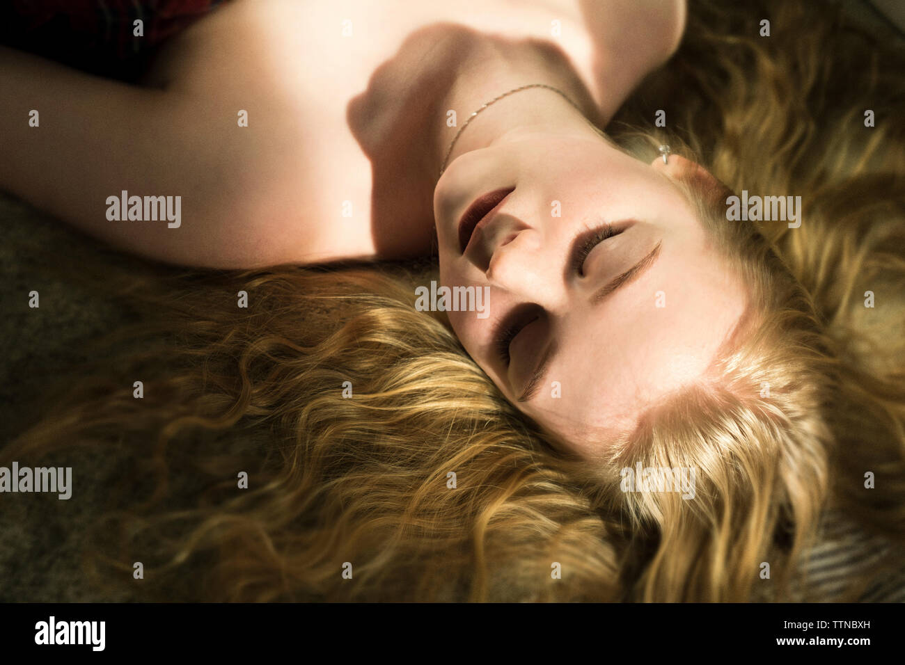 Portrait de femme aux cheveux blonds de dormir sur le lit chez lui Banque D'Images