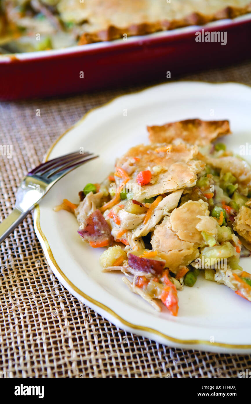 Vue en grand angle de la tarte au poulet servie dans une assiette avec fourchette sur la table à la maison Banque D'Images