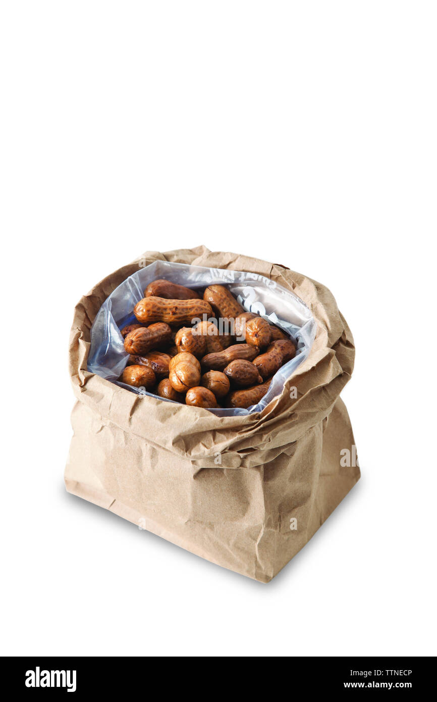 Gros plan des arachides bouillies dans un sac de papier brun sur fond blanc Banque D'Images