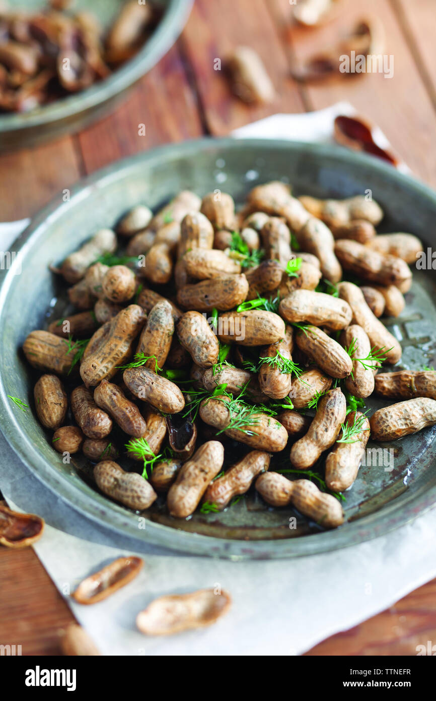 Gros plan des arachides bouillies garnies dans une assiette sur la table à la maison Banque D'Images