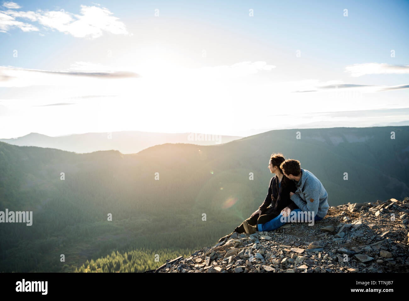 Couple assis sur la falaise et la montagne looking at view Banque D'Images