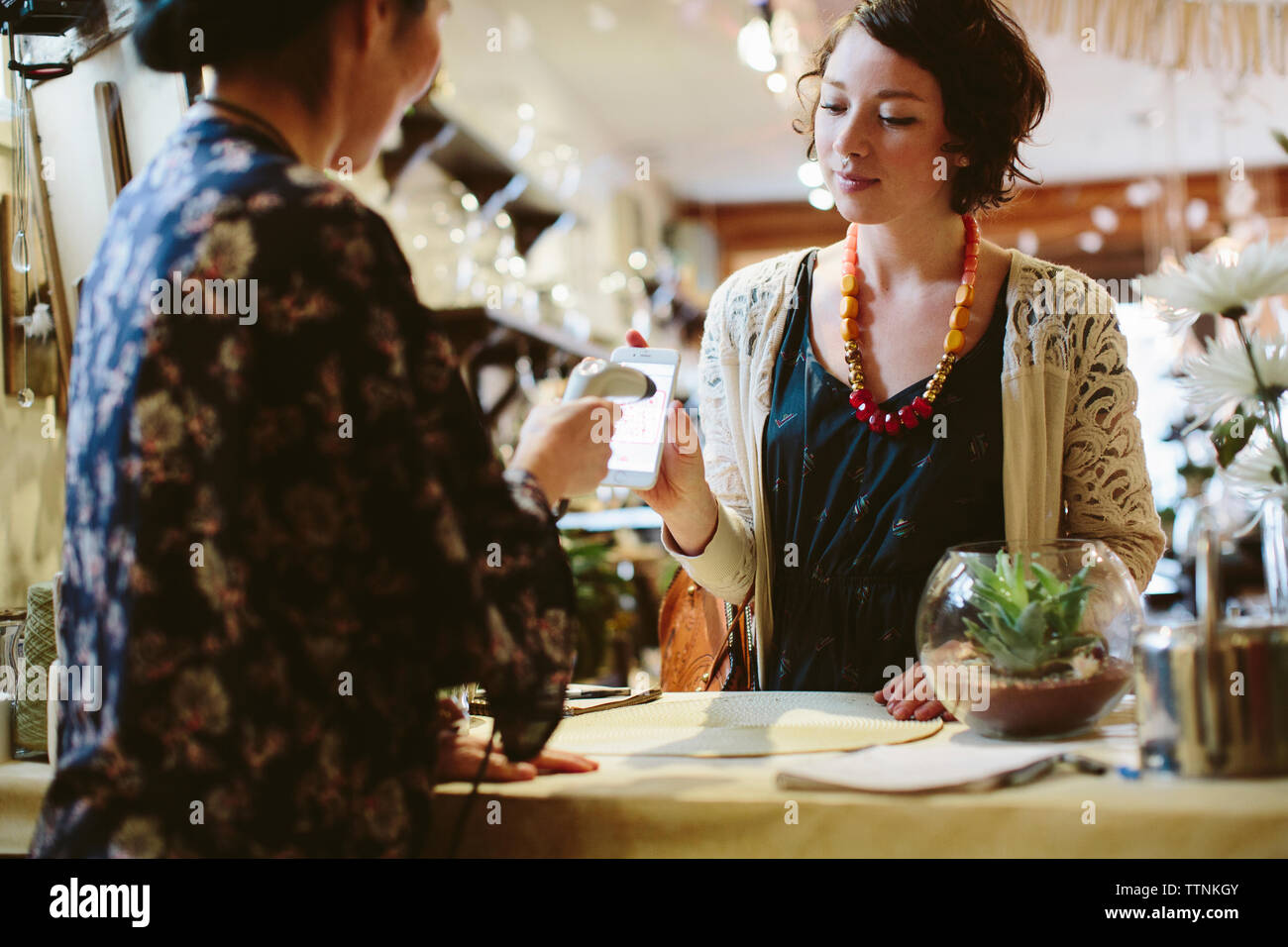 Code QR de numérisation propriétaire téléphone mobile holding par le client au magasin de l'usine Banque D'Images