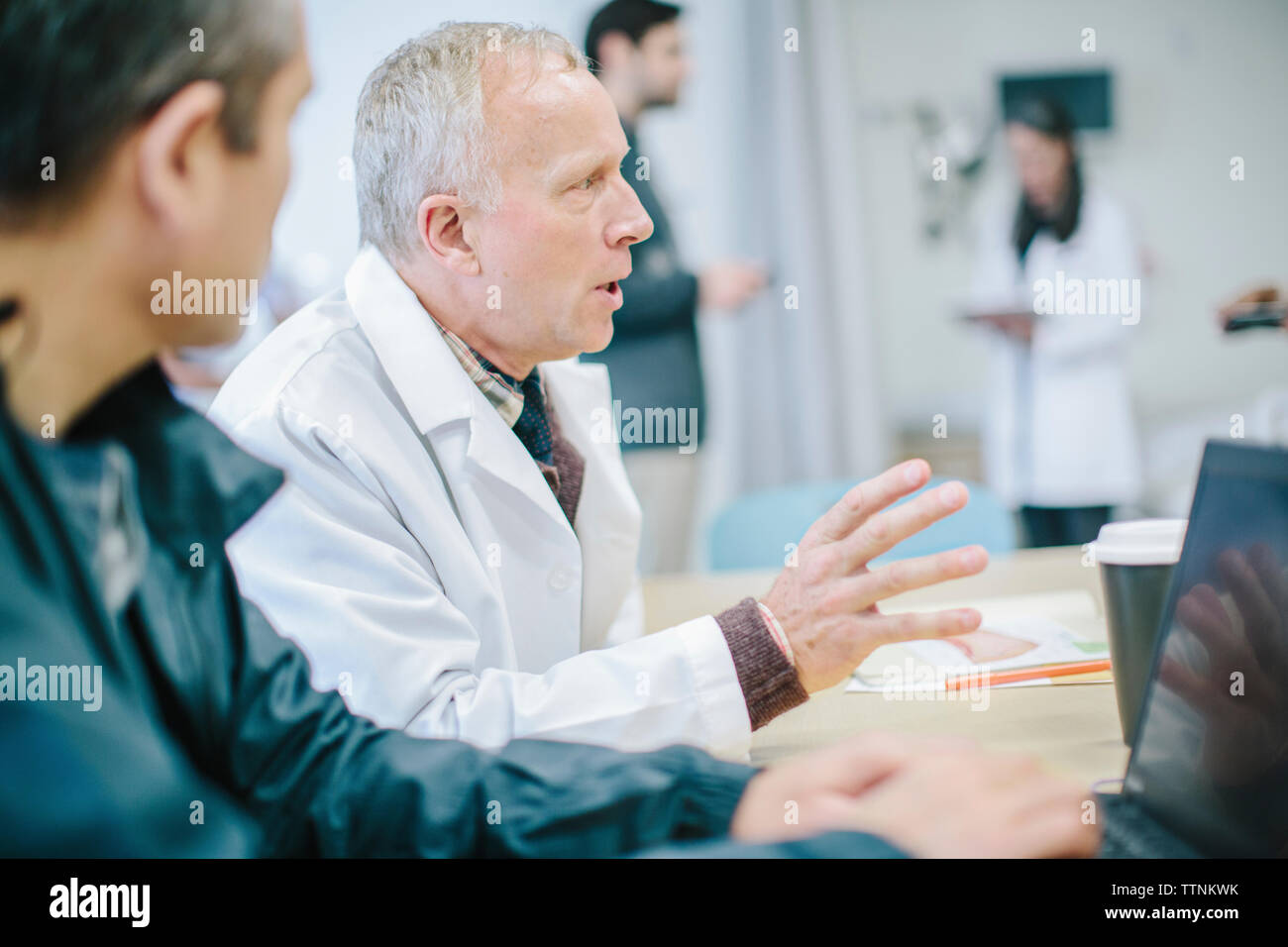 Les médecins de discuter à table dans la salle médicale à l'hôpital Banque D'Images