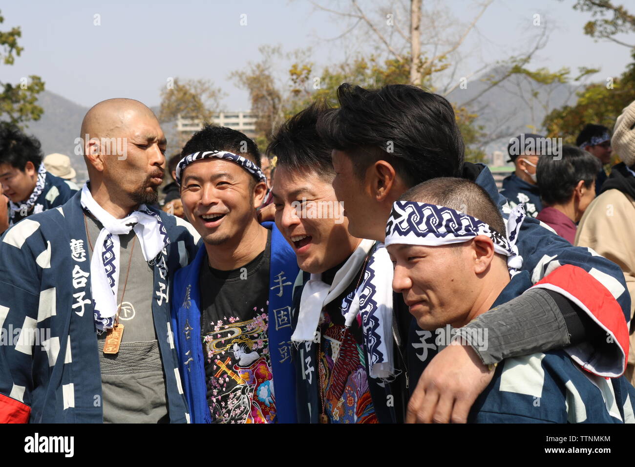 Les jeunes hommes de célébrer et de rire après avoir poussé flotte dans le port de bandeaux et festival Inuyama vestes traditionnelles Banque D'Images