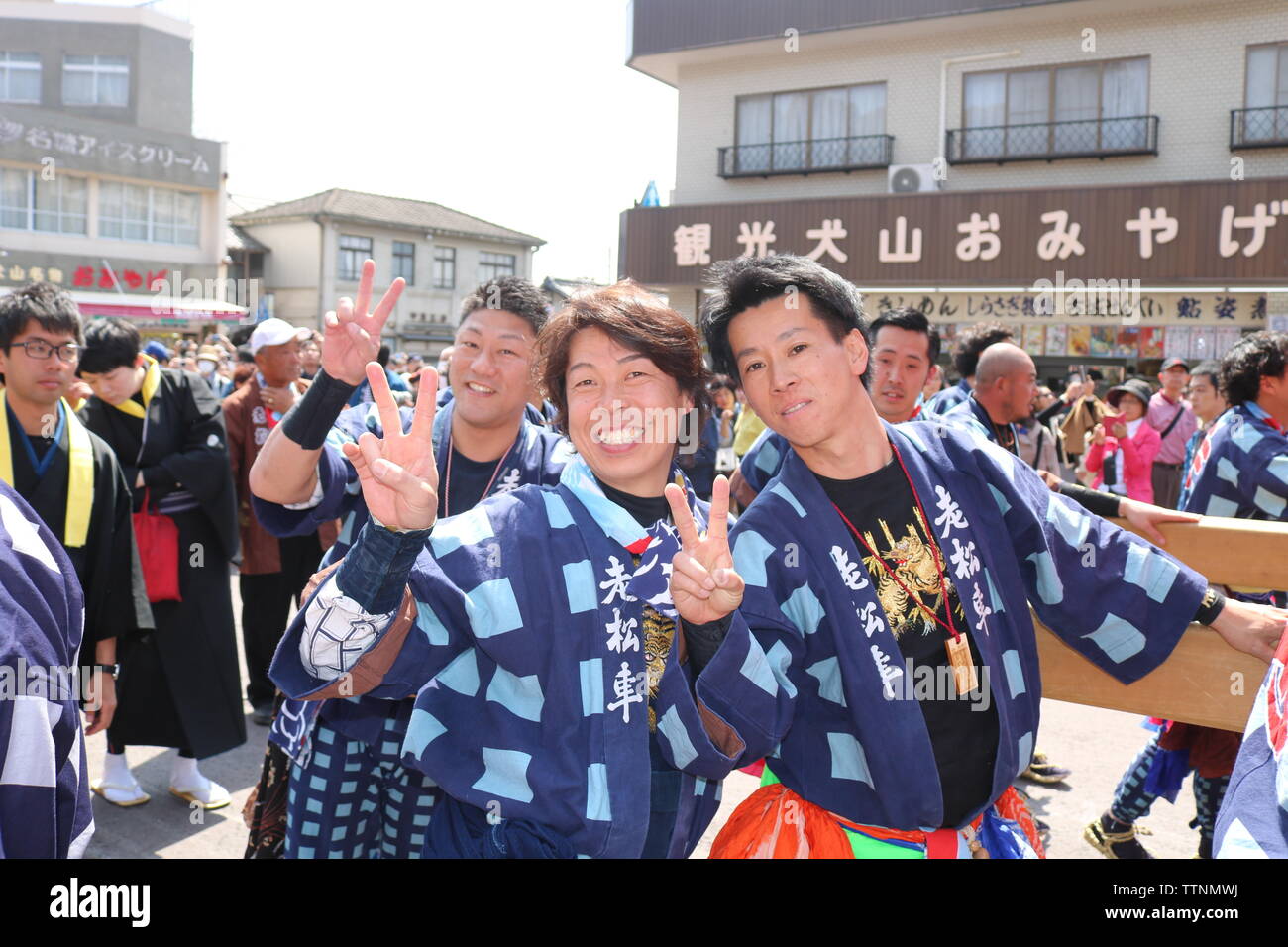 Les jeunes hommes de célébrer et de rire après avoir poussé flotte dans le festival Inuyama montrant le geste de paix deux doigts Banque D'Images