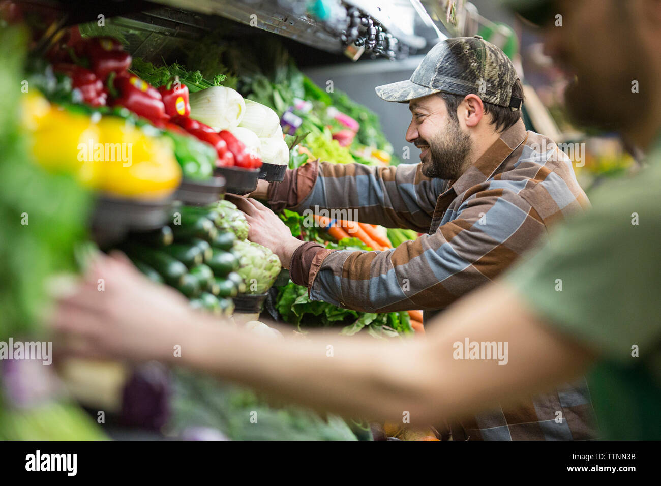 les ouvriers organisent des légumes au supermarché Banque D'Images