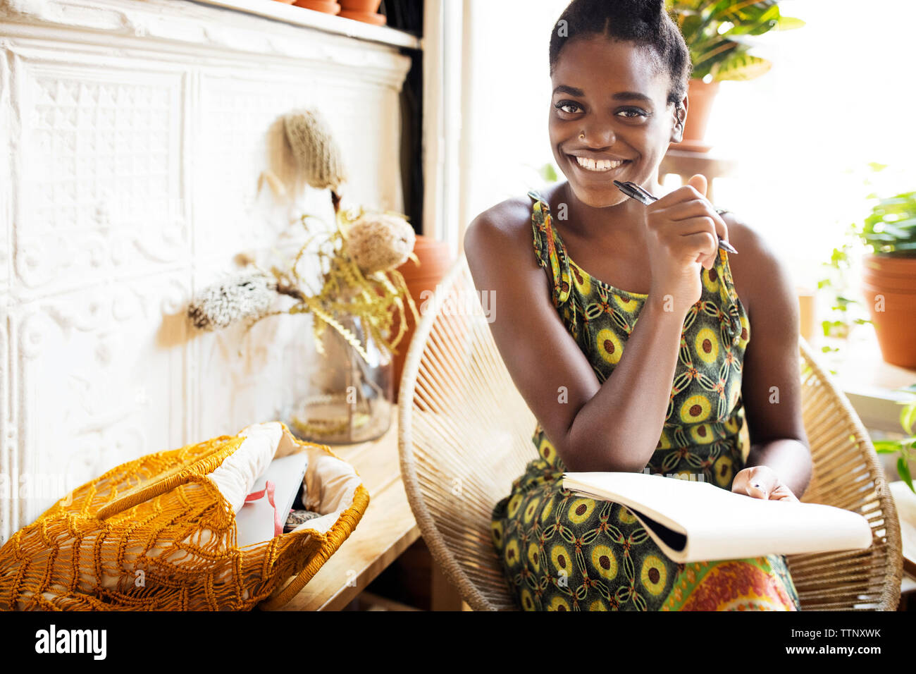 Portrait of woman holding pen et notes par store Banque D'Images