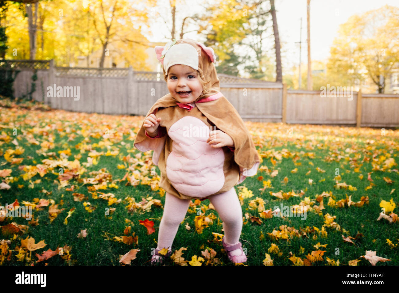 Portrait of happy baby girl wearing costume oiseau at park Banque D'Images