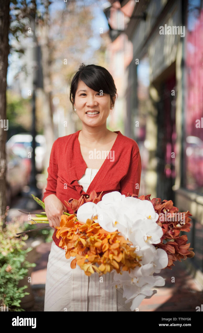 Portrait de femme propriétaire holding bouquets alors que l'article d'un magasin Banque D'Images