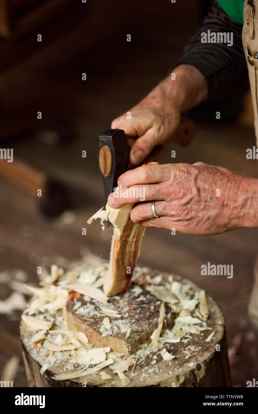 Portrait de l'imageur carpenter façonner le bois avec un burin marteau à l'atelier Banque D'Images