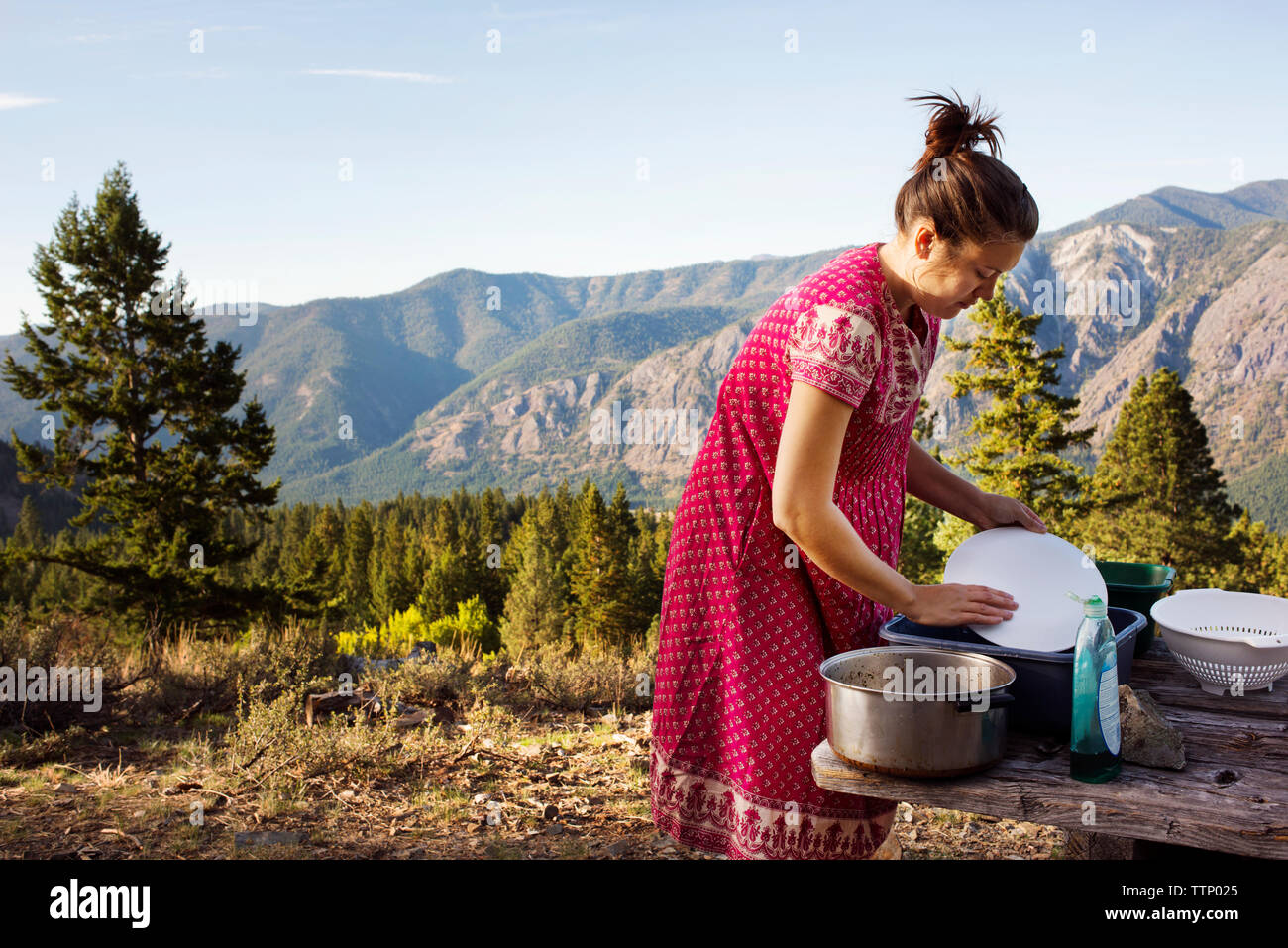 Vue de côté femme ustensiles de nettoyage en montagne Banque D'Images