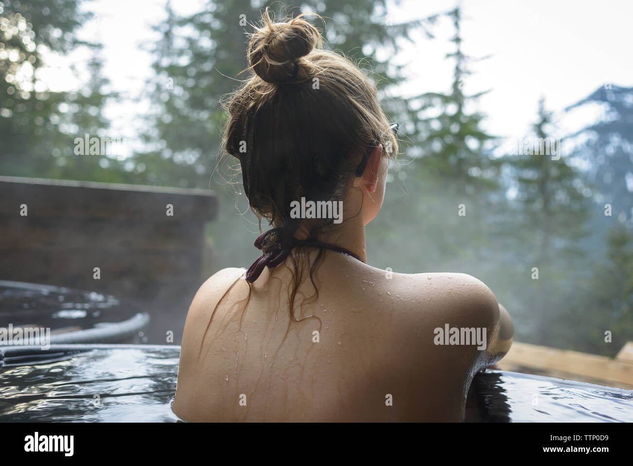 Rear view of woman in Hot spring baignoire Banque D'Images