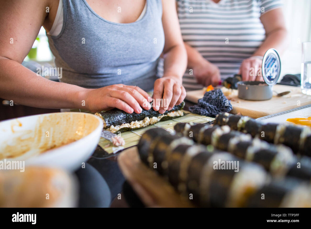 Portrait de la femme de faire des sushis à la maison sur l'île de cuisine Banque D'Images