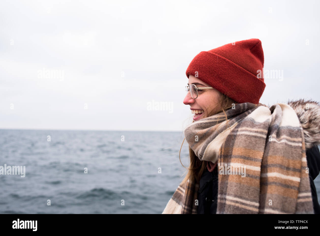 Profil de la femme élégante de rire en face du lac en hiver Banque D'Images