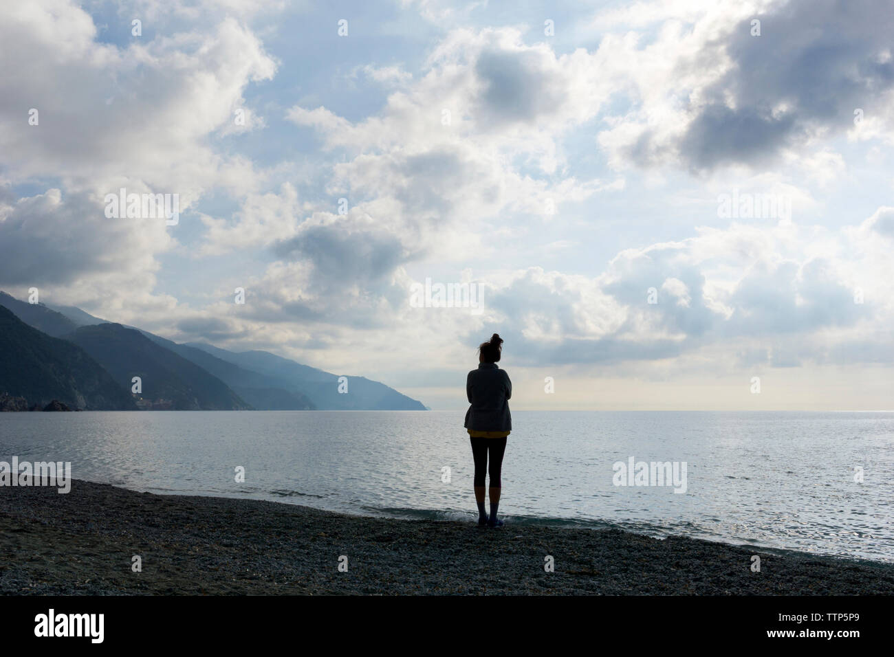 Silhouette de femme debout sur le rivage à Beach Banque D'Images