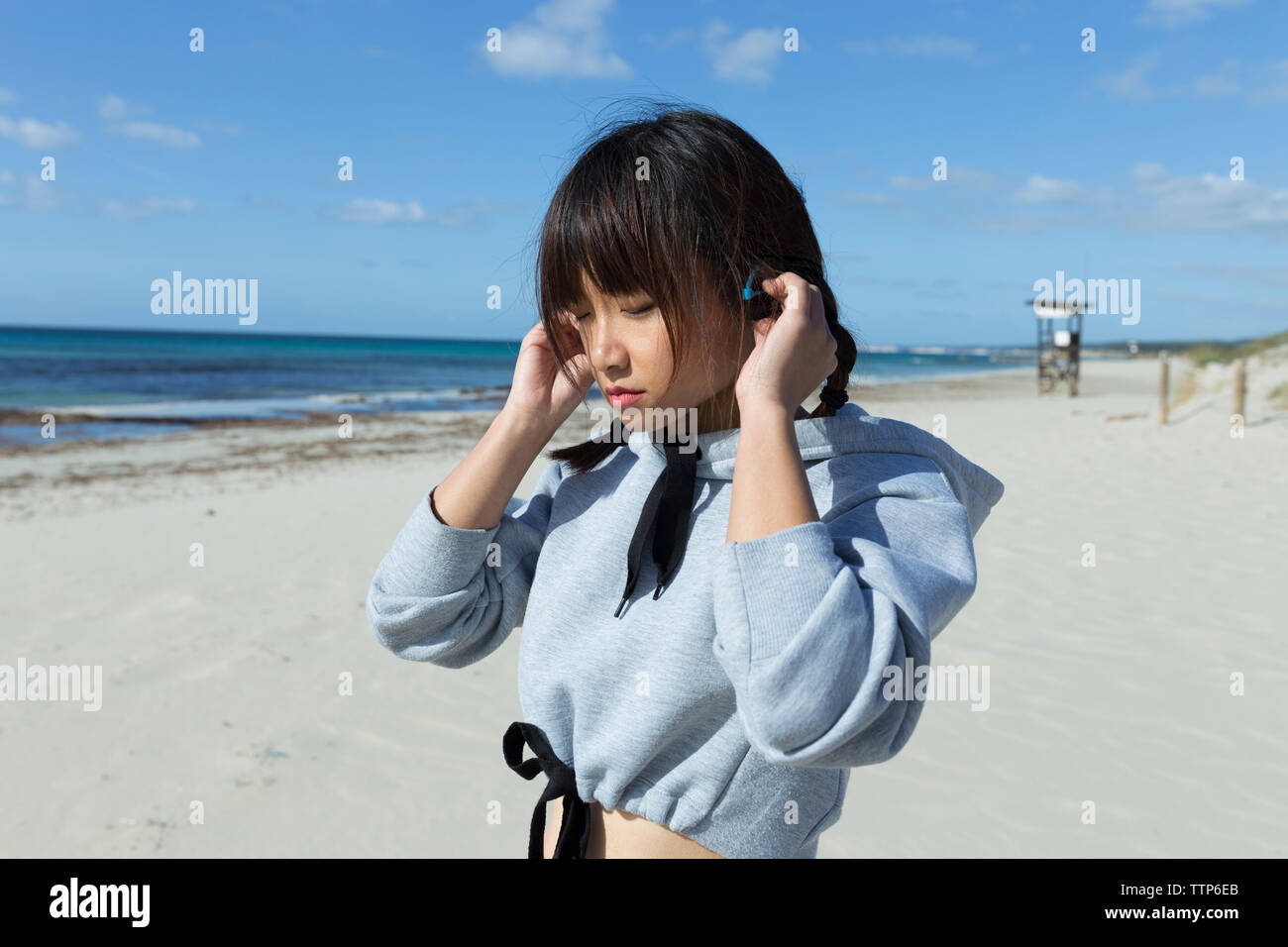 Femme asiatique sur la plage d'écouter la musique avec des écouteurs sans fil Banque D'Images
