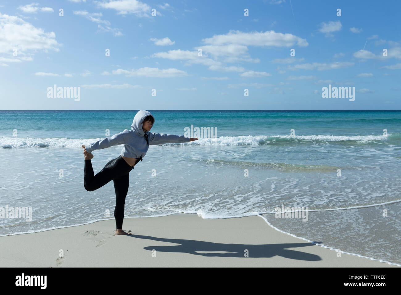 Asian woman stretching sur la plage le matin Banque D'Images