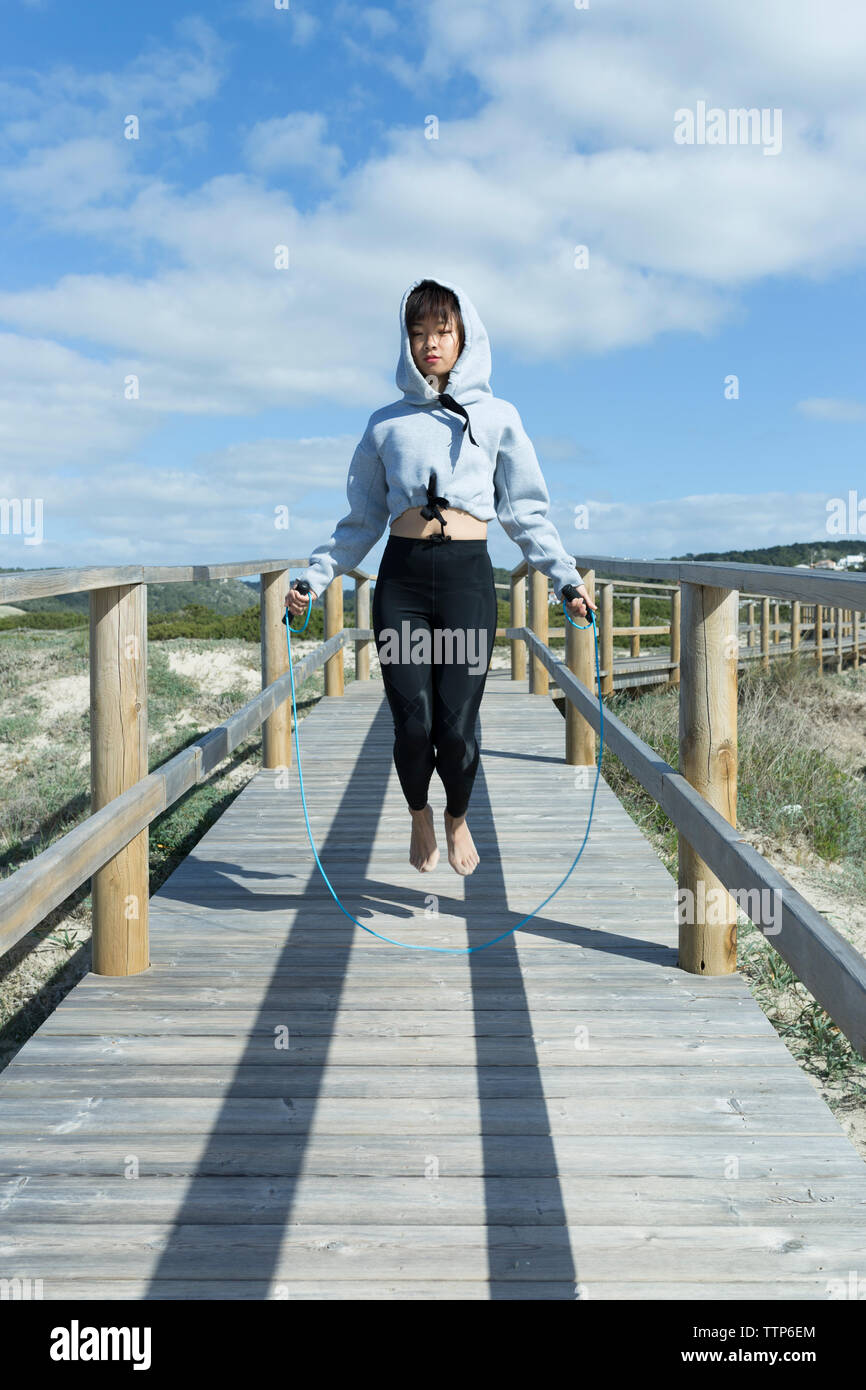 Femme chinoise asiatique la corde à sauter pieds nus dans journée ensoleillée Banque D'Images