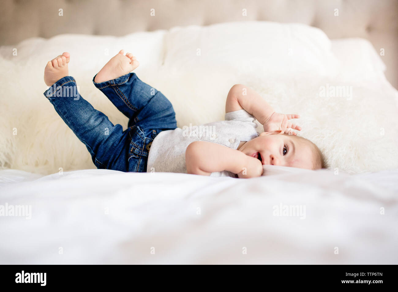 Baby Boy laying on retour sur bed looking at camera Banque D'Images