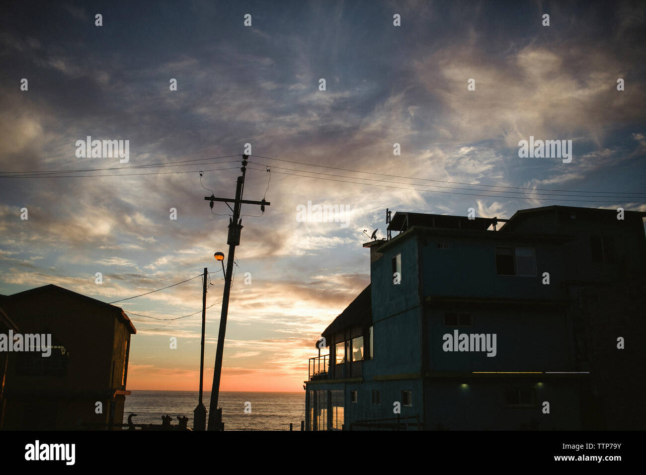 Low angle view de bâtiments à la silhouette ciel nuageux pendant le coucher du soleil Banque D'Images