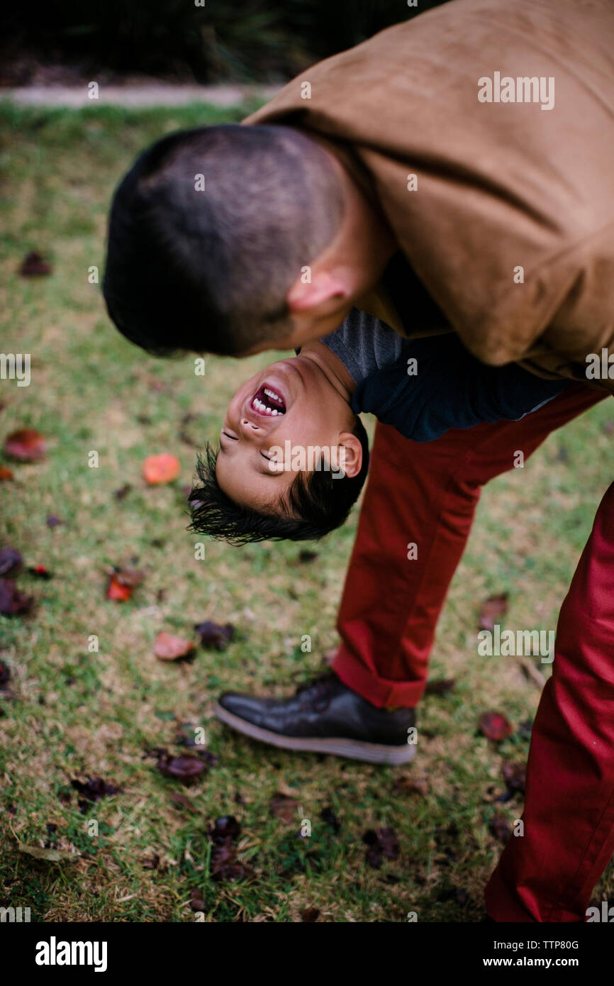High angle view of playful père exerçant son fils heureux en se tenant sur le terrain d'herbe dans le Parc Balboa Banque D'Images