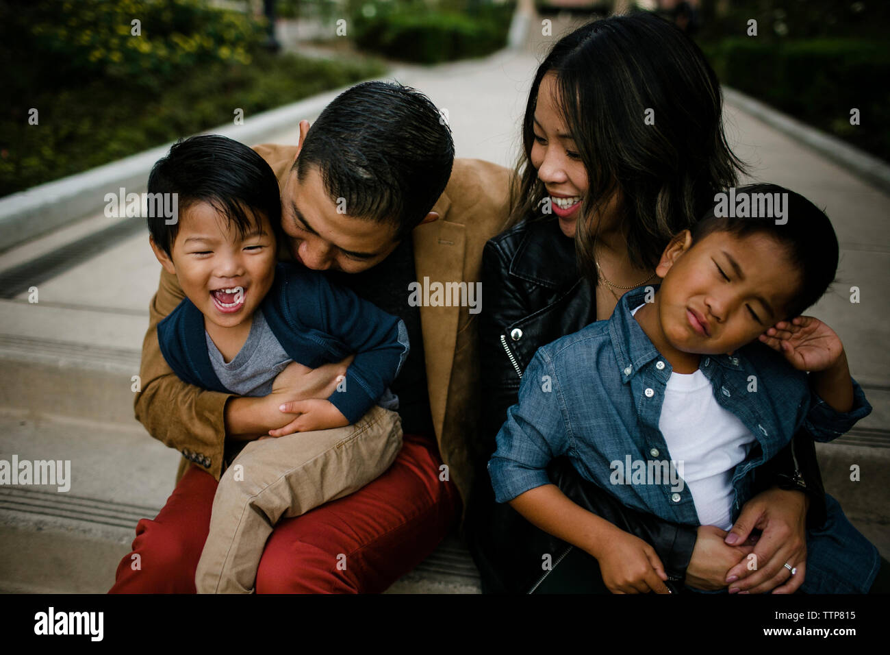 Portrait of happy parents avec mignon fils assis sur les marches à Balboa Park Banque D'Images
