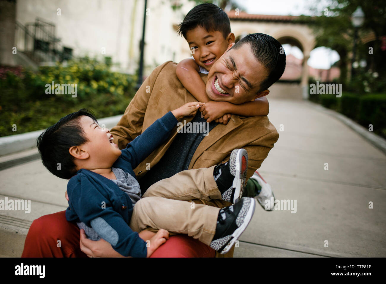 Heureux père jouant avec fils alors qu'il était assis sur les marches à Balboa Park Banque D'Images