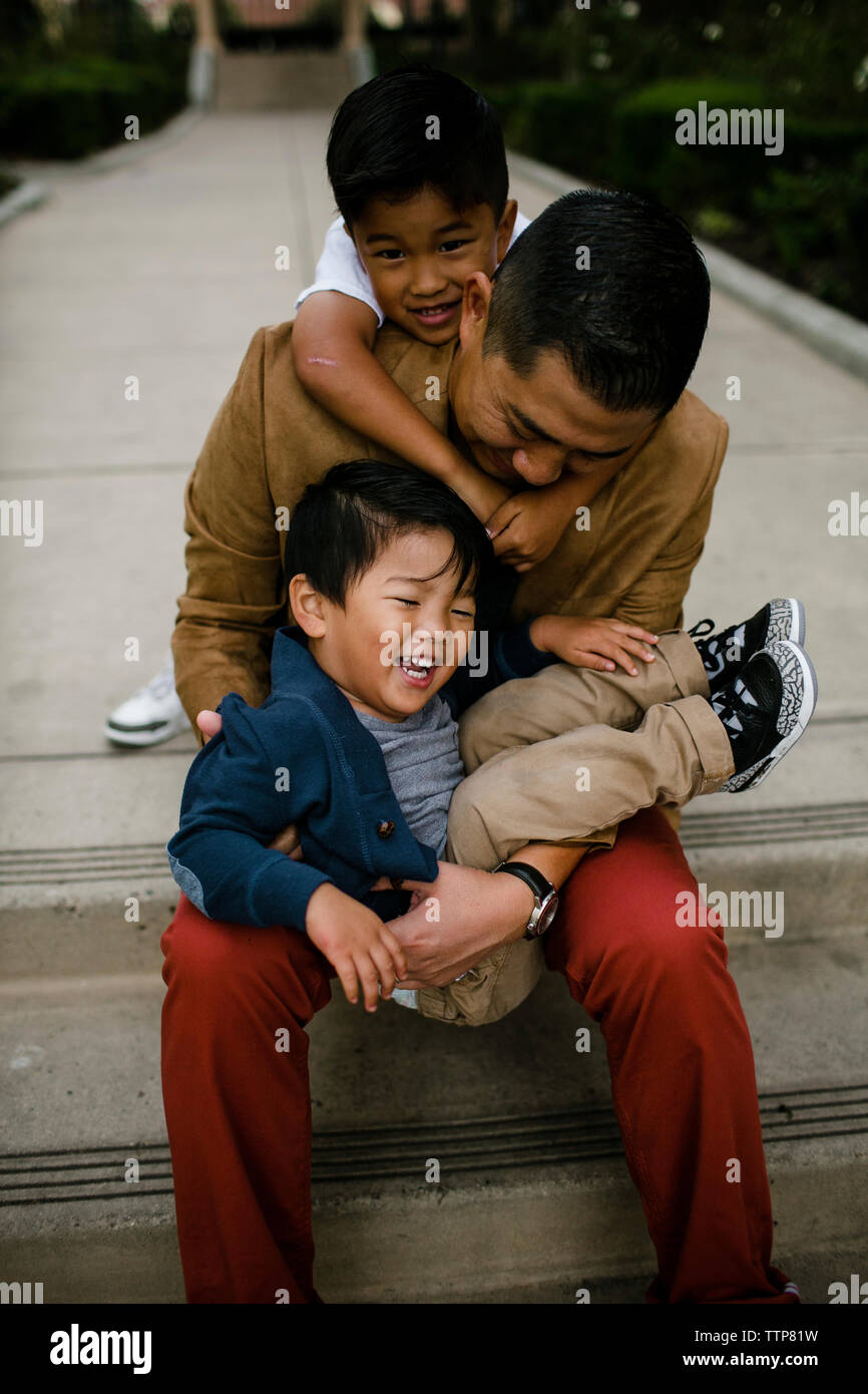 High angle view of happy père jouant avec fils alors qu'il était assis sur les marches à Balboa Park Banque D'Images