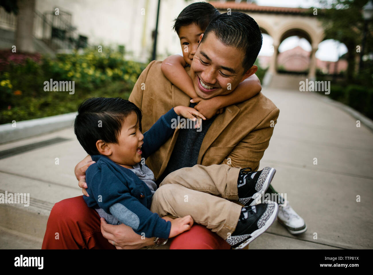 Heureux père jouant avec fils alors qu'il était assis sur les marches dans le Parc Balboa Banque D'Images