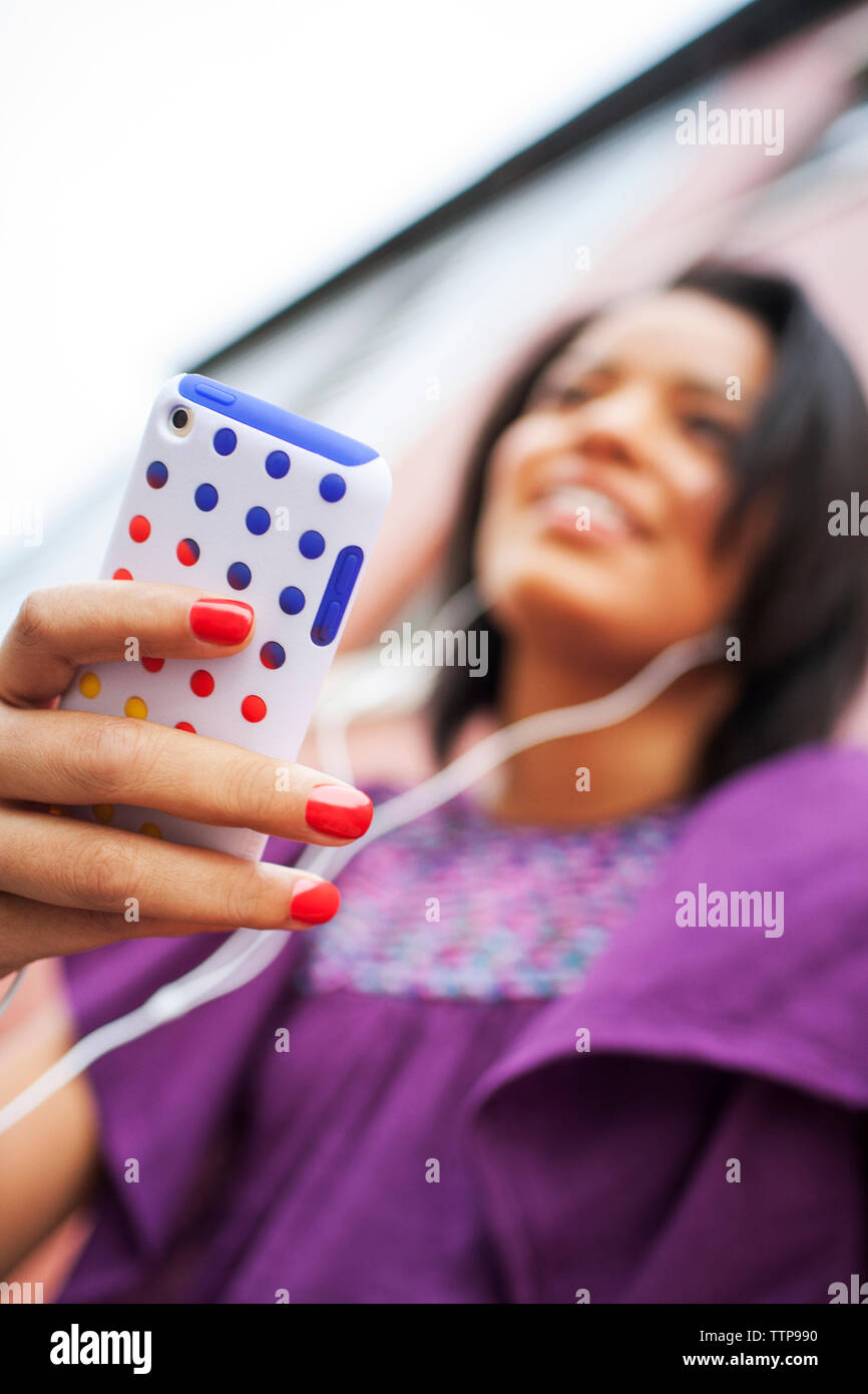 Low angle view of young woman holding smart phone Banque D'Images