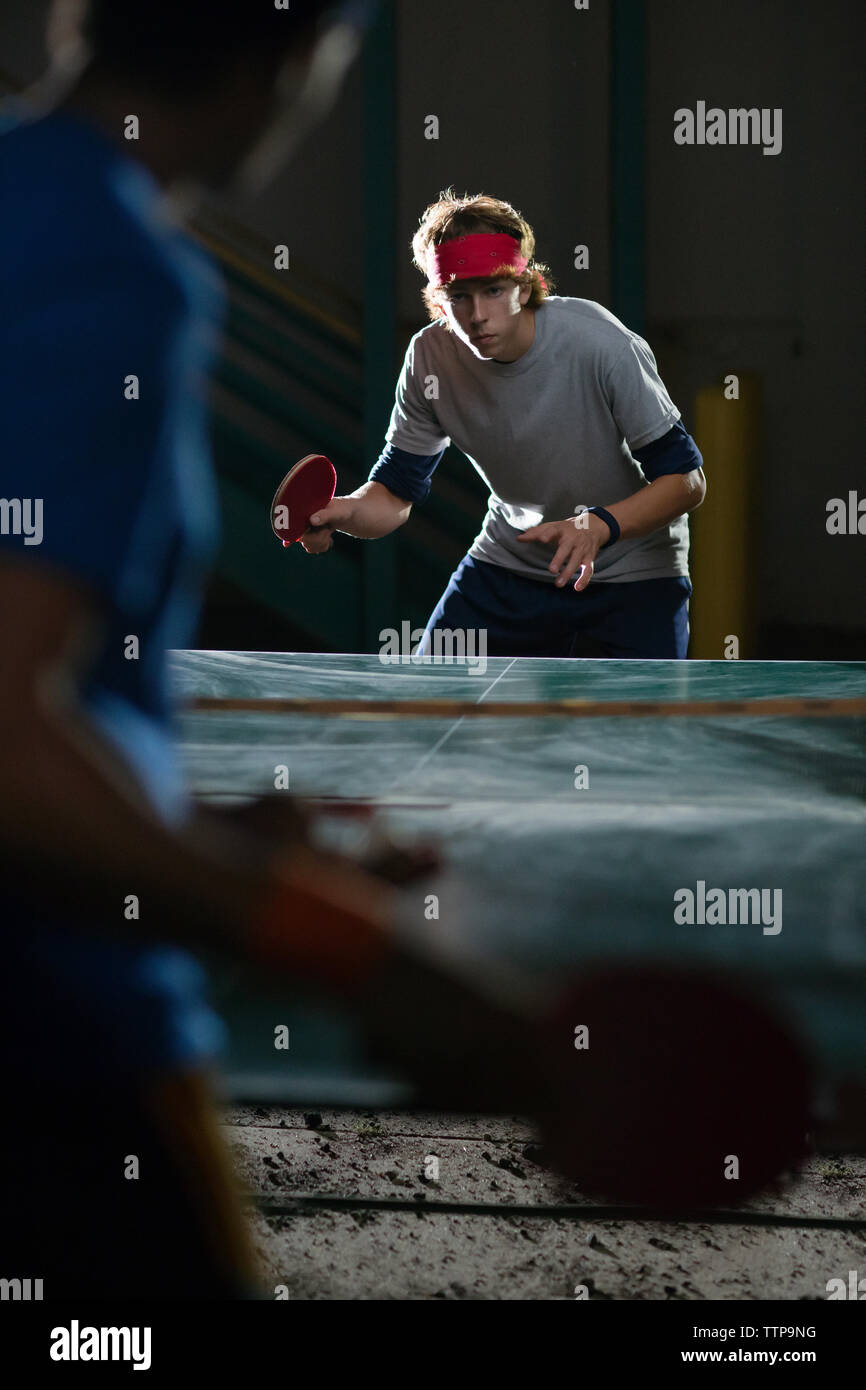 Jeunes amis à jouer au tennis de table de nuit Banque D'Images