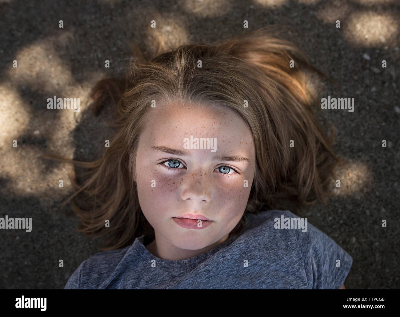 Passage young girl lying on road Banque D'Images