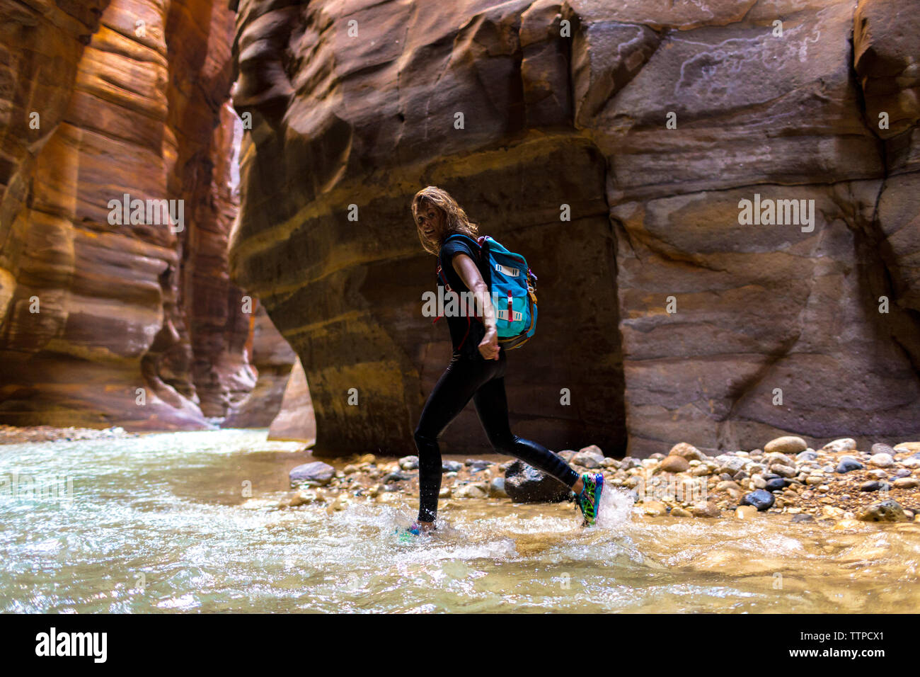 Portrait de femme backpacker walking in river de montagnes Banque D'Images