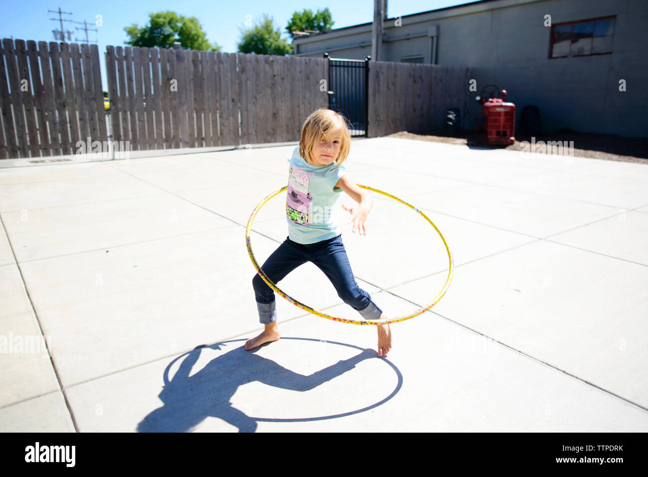 Portrait of Girl Playing with hula hoop à jeux pour enfants en été Banque D'Images