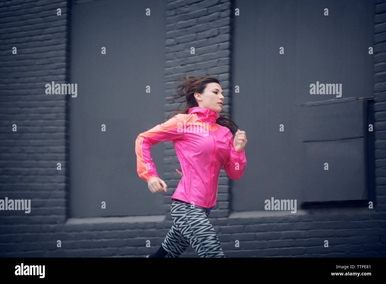 Grande sportive en marche contre le bâtiment Banque D'Images