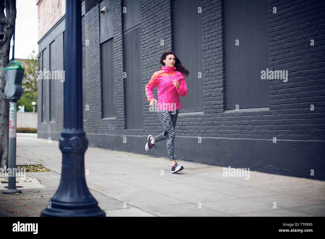 Grande sportive s'exécutant sur trottoir Banque D'Images