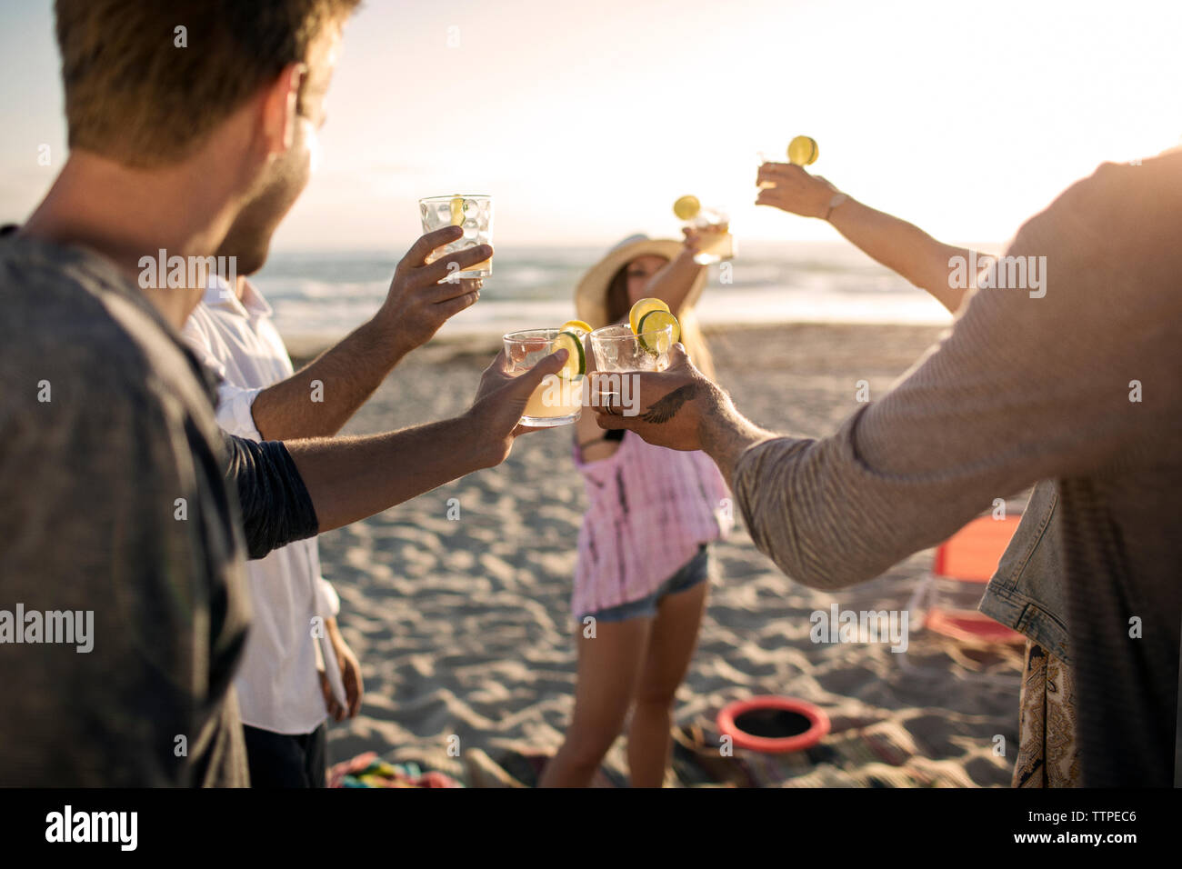 Cheerful friends toasting drinks on beach Banque D'Images
