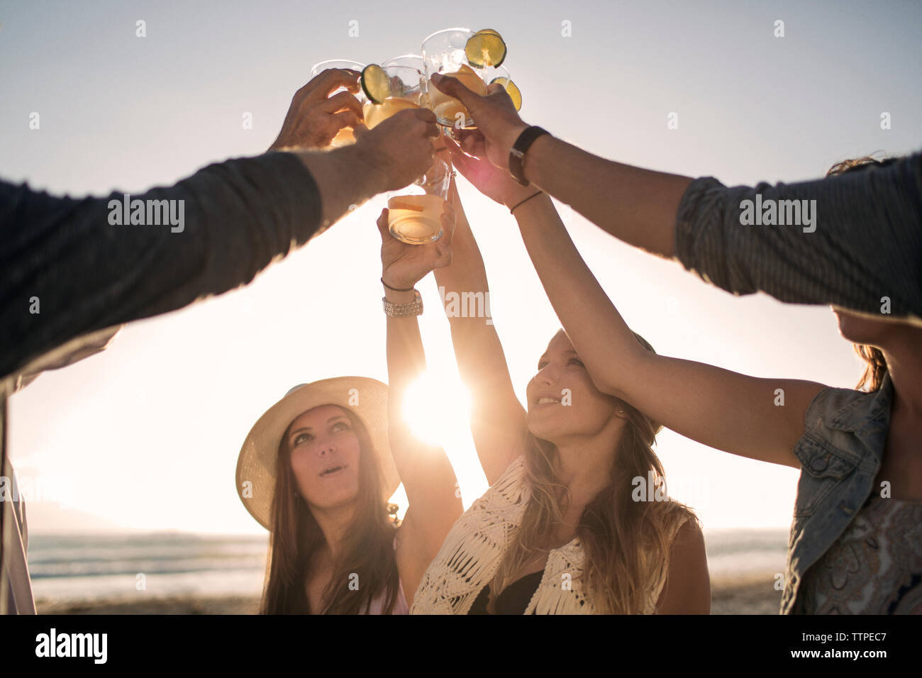 Happy friends toasting drinks on beach Banque D'Images