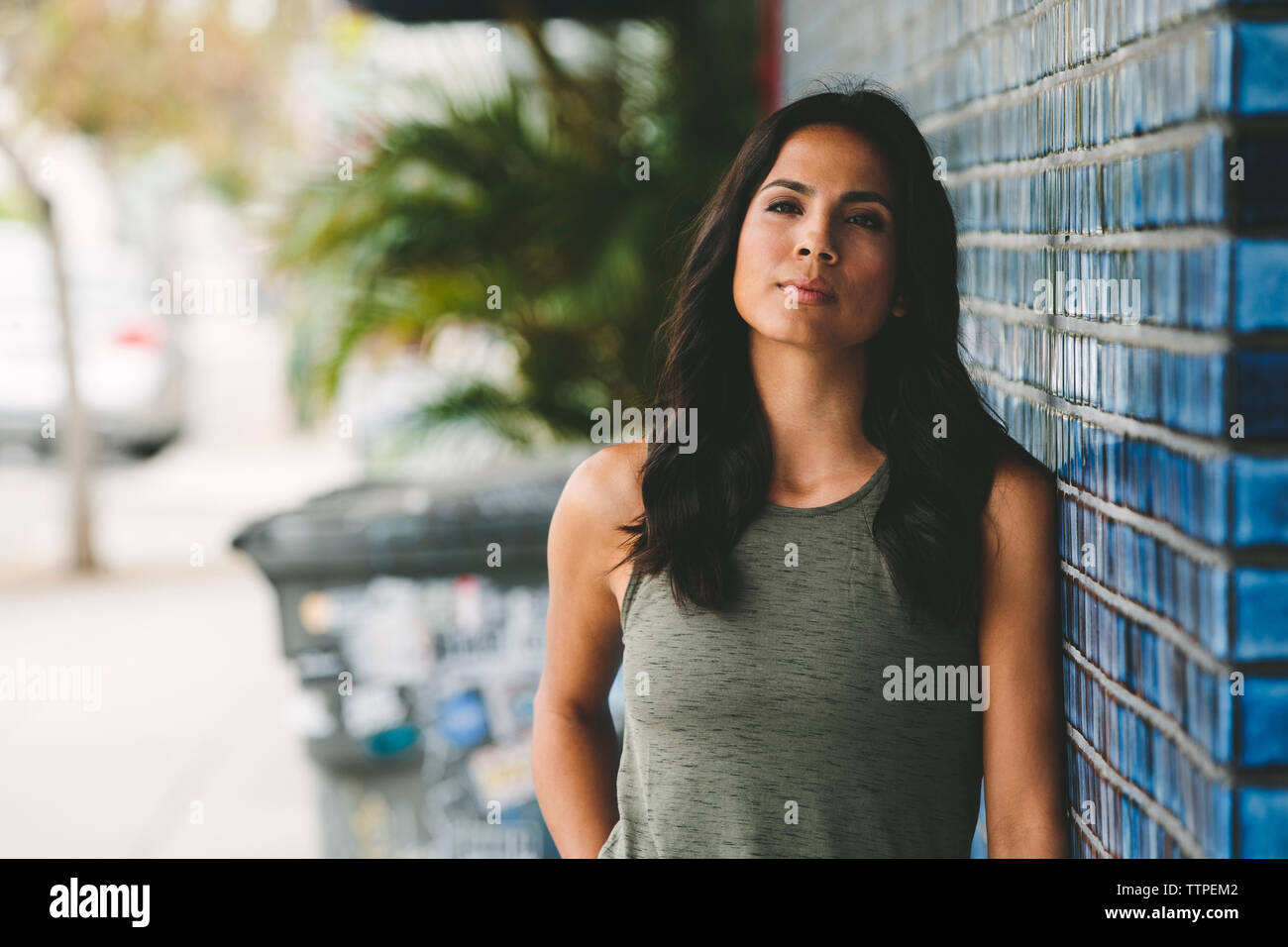Portrait of young woman leaning on wall Banque D'Images
