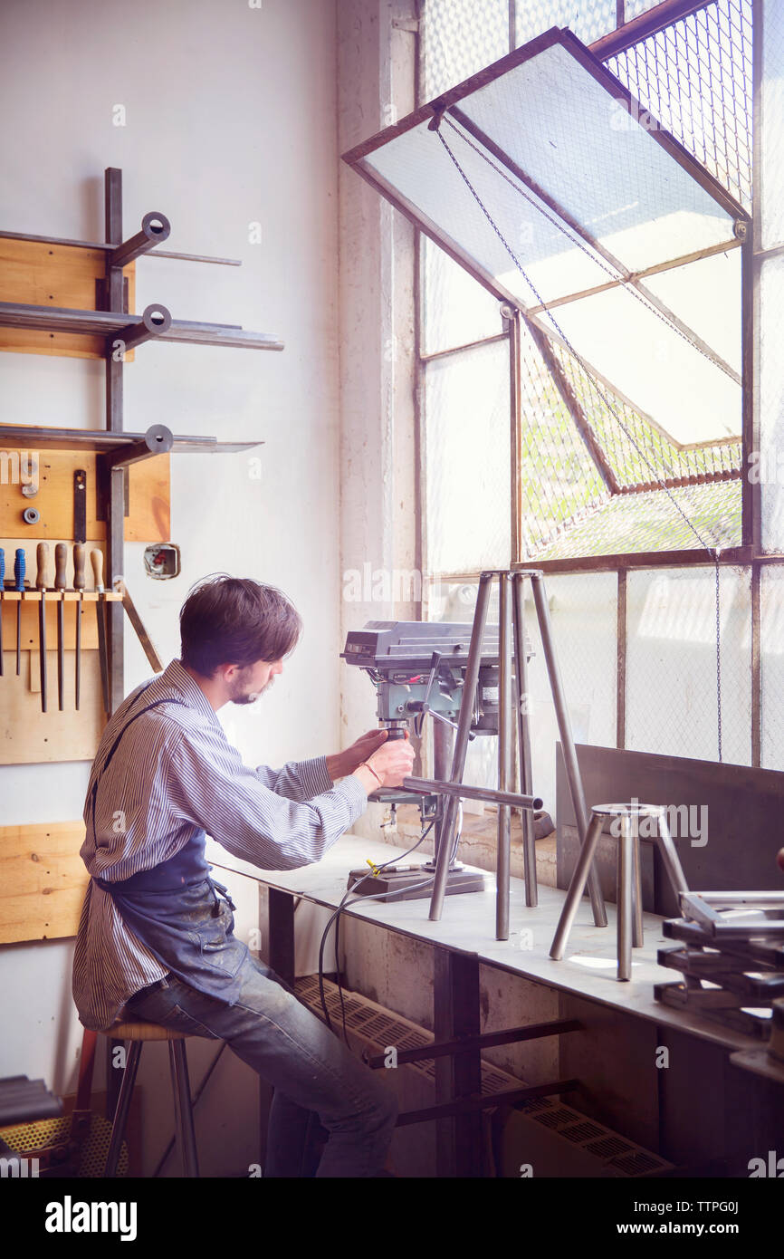 Artiste masculin travaillant sur machines à wood shop Banque D'Images