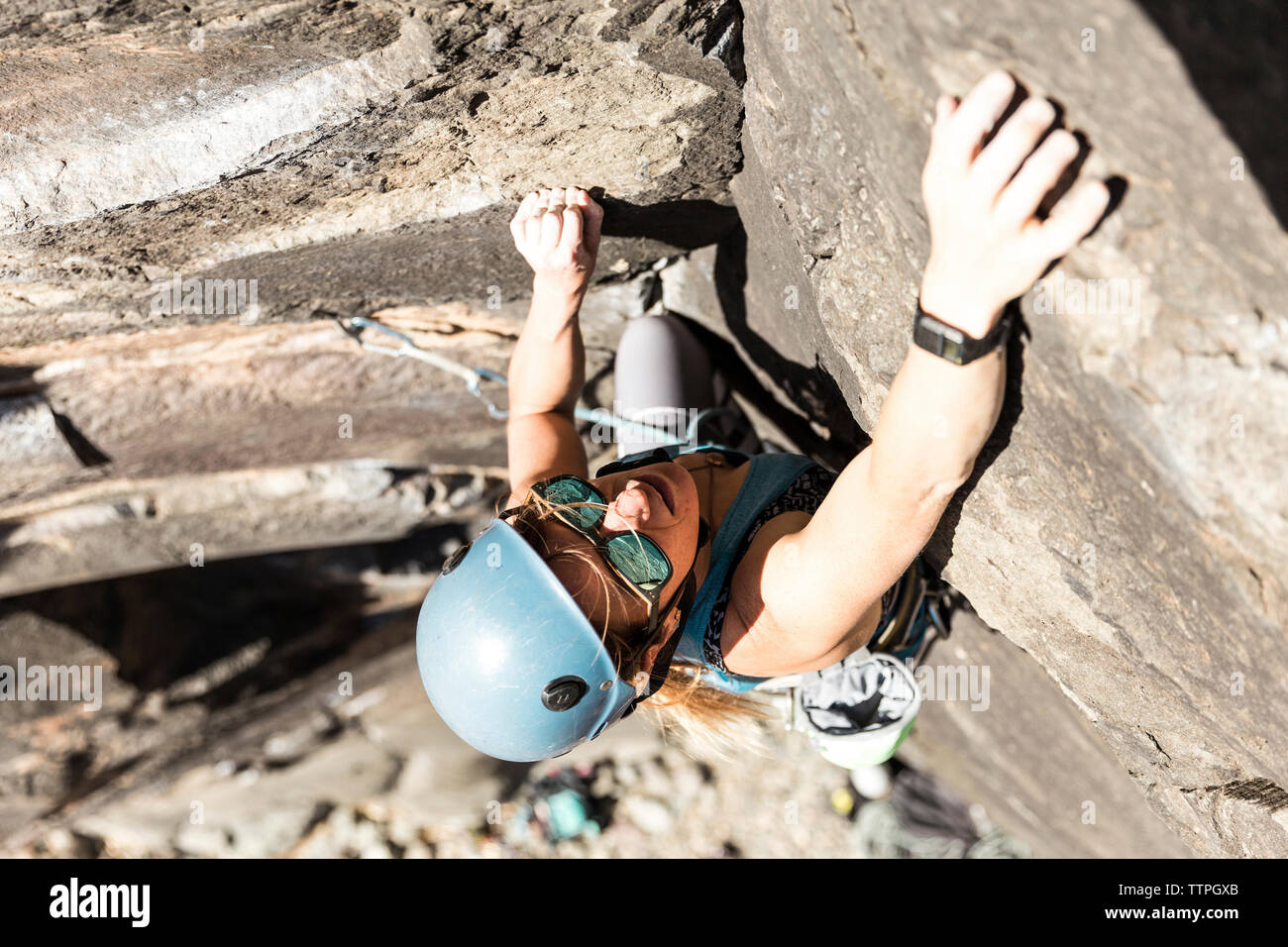 High angle view of female hiker wearing helmet alors que l'escalade en montagne au cours de journée ensoleillée Banque D'Images