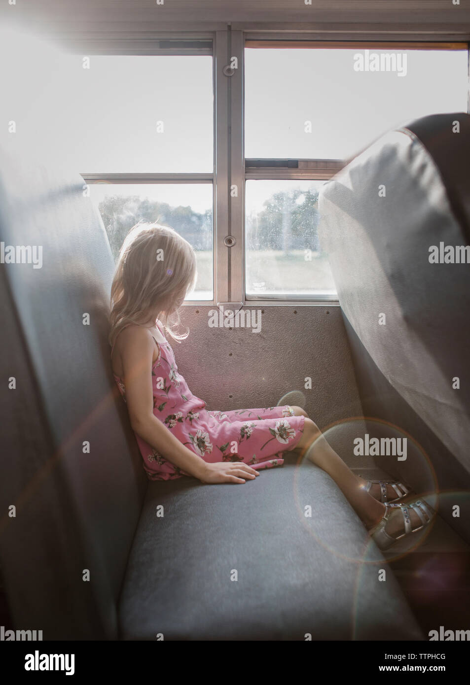 Vue de côté de fille avec des cheveux blonds assis par bus dans la fenêtre Banque D'Images