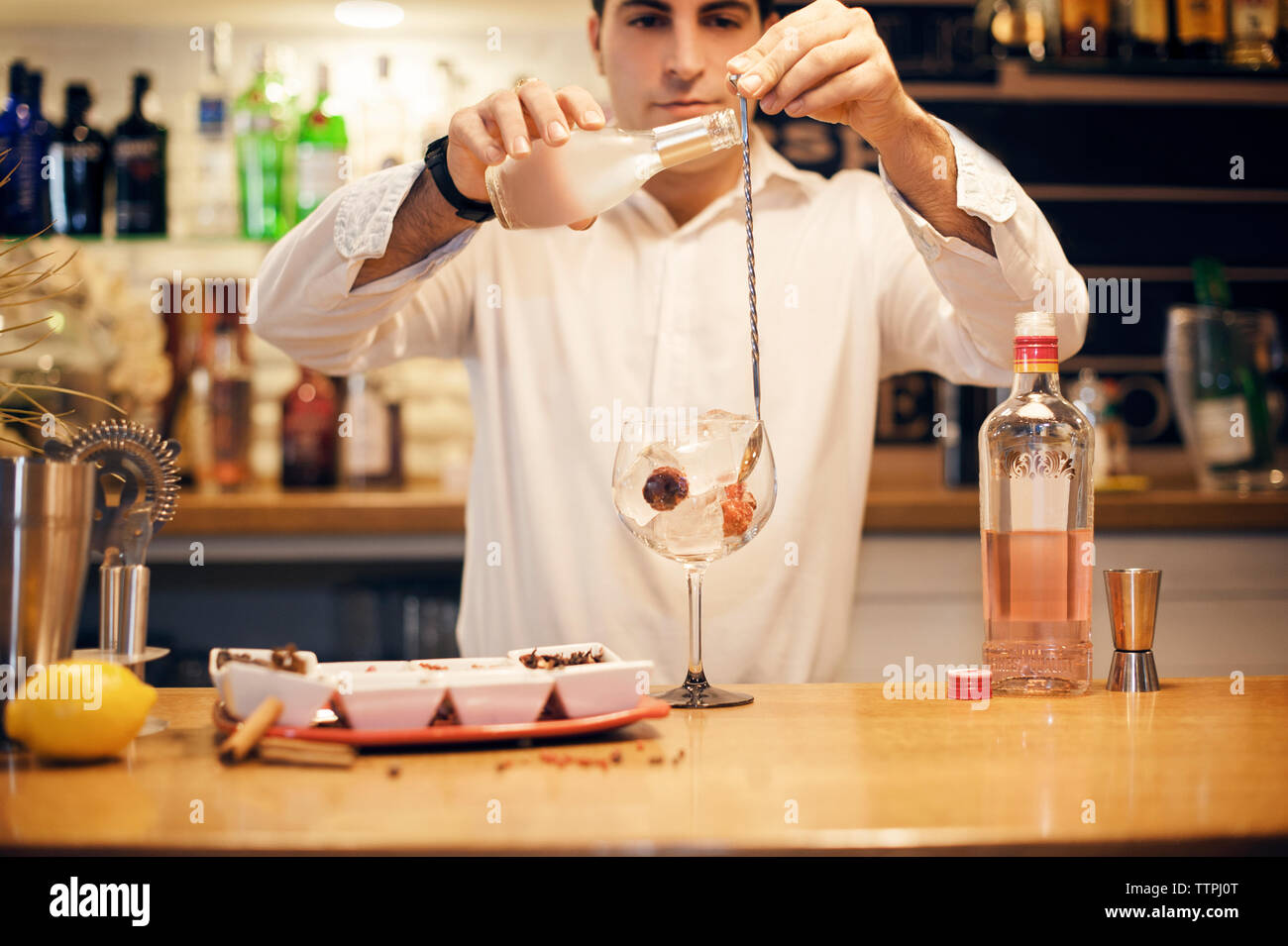 Jeune barman cocktail préparation au comptoir Banque D'Images