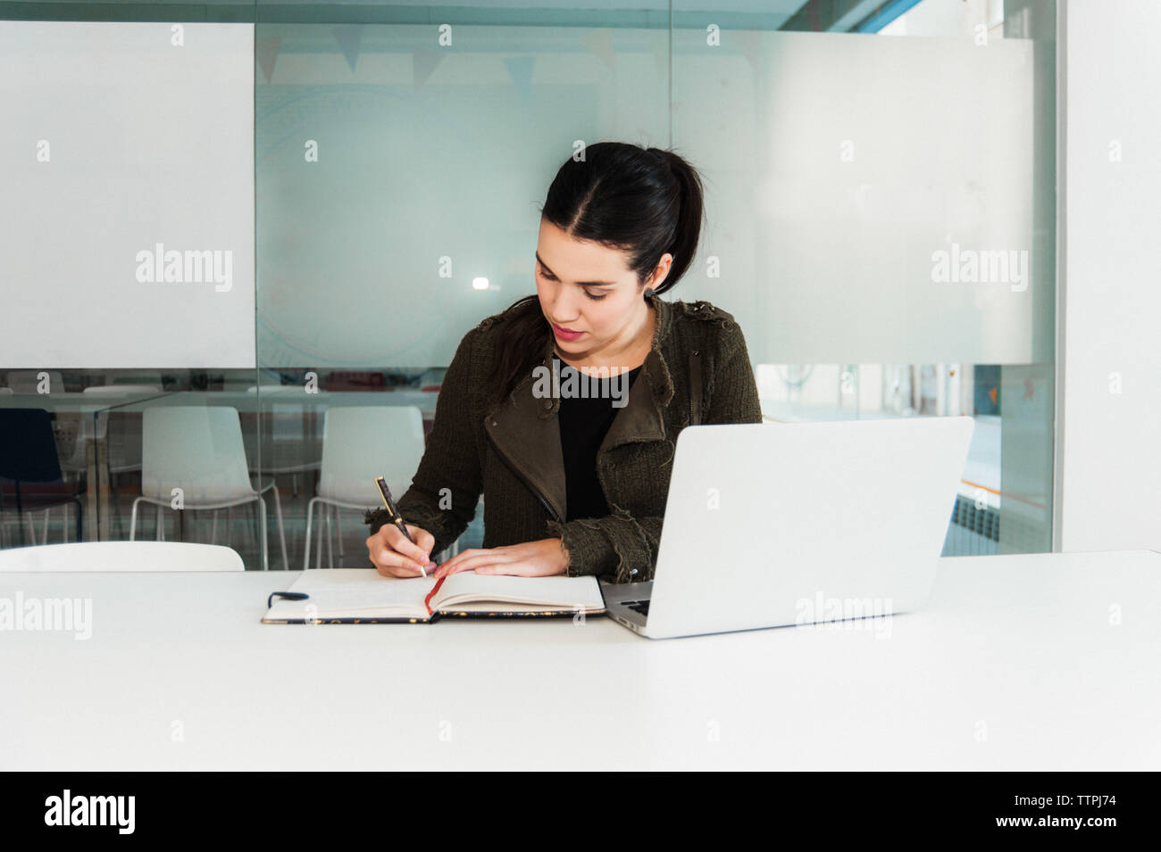Young Hispanic Woman working on Laptop in Classroom Banque D'Images