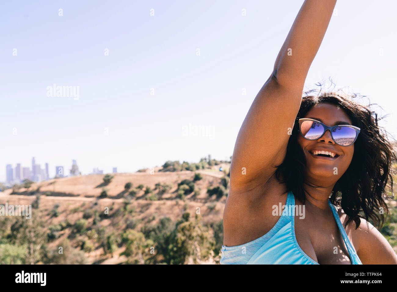 Happy woman stretching tout en exerçant à l'encontre de ciel clair Banque D'Images
