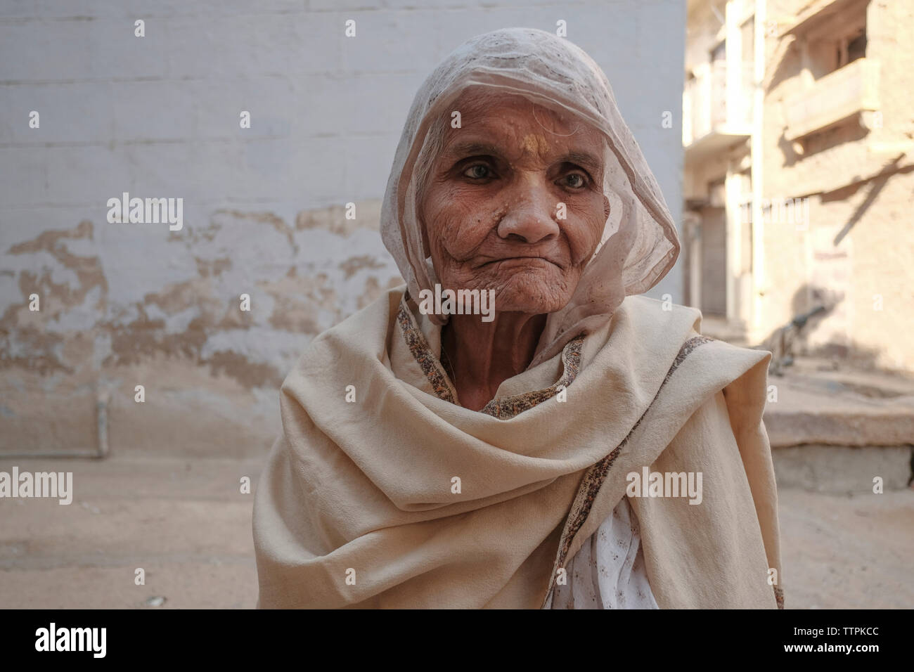 Senior woman wearing sari avec couverture contre maison en ville Banque D'Images